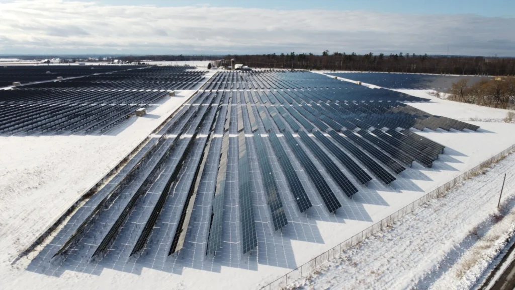 Aerial view of a utility-scale solar farm demonstrating snow load solar racking performance in heavy winter conditions.