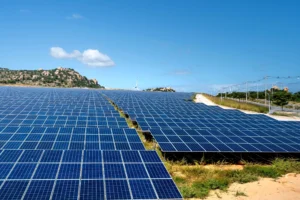 Rows of ground mount solar panels on a green field under sunny blue sky