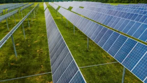 Utility-scale solar panels installed on a ground screw solar mount system in a green field.