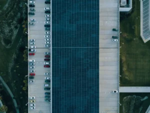 Top-down aerial view of a modern residential solar carport canopy integrated into a parking lot, showcasing solar panels capturing clean energy.